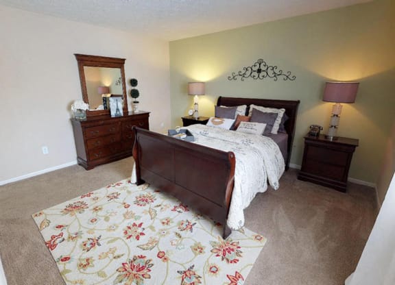 a bedroom with a bed and two dressers  at Hunter's Creek Apartments, Ohio, 45242