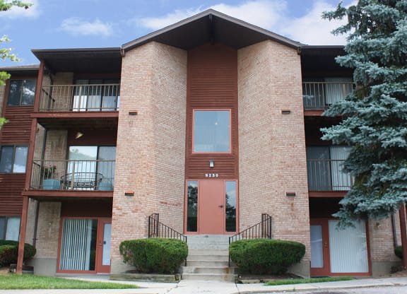 a brick apartment building with a red door and balconies  at Four Worlds Apartments, Cincinnati, 45231