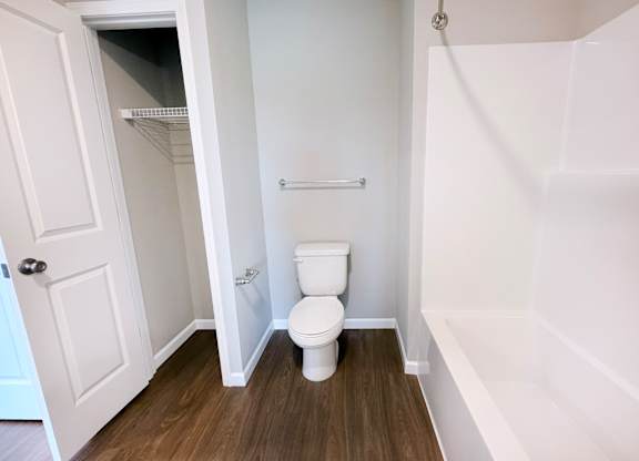 A white toilet in a small bathroom with a white door.