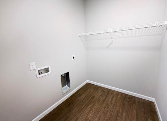 A white wall with a shelf and a socket.