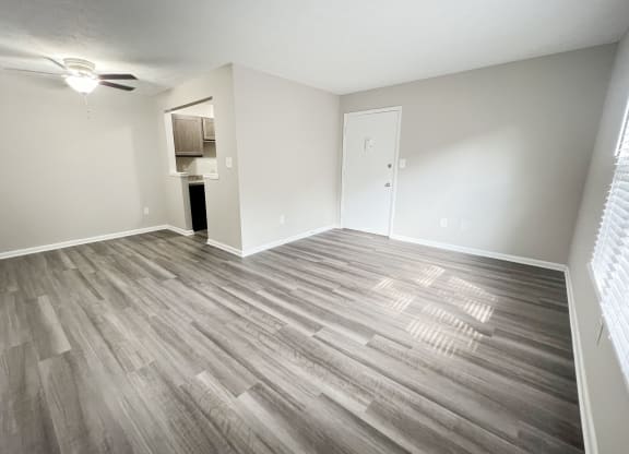 an empty living room with wood flooring in an apartment at Revere Village Apartments, Centerville, OH, 45458