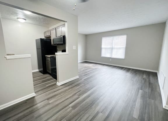 an empty living room and kitchen with hardwood flooring at Revere Village Apartments, Centerville, Ohio