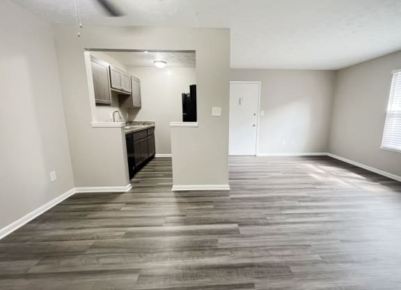 an empty living room with wood floors and a kitchen at Revere Village Apartments, Centerville