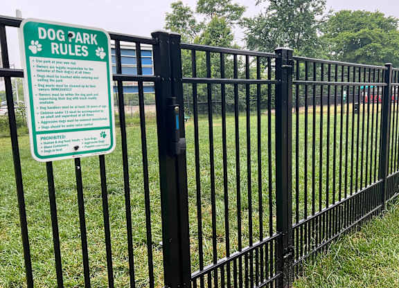 A sign in a dog park outlines the rules for visiting the park.