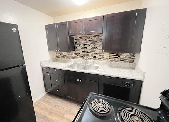 a kitchen with black appliances and dark wood cabinets at Barkley Ridge Apartments, Southgate, 41071