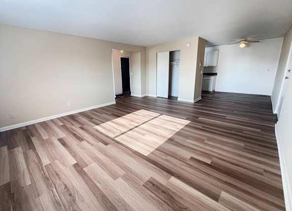 A room with wooden flooring and white walls.