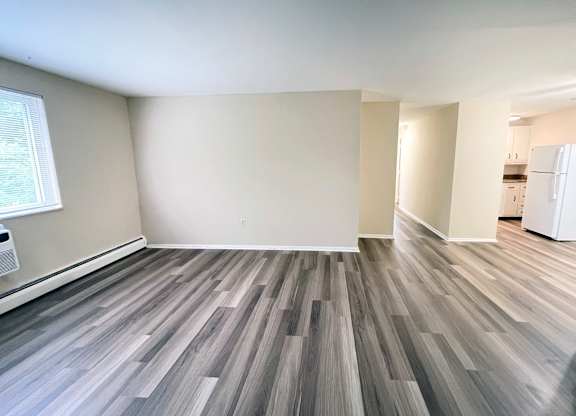 A room with wooden flooring and white walls.