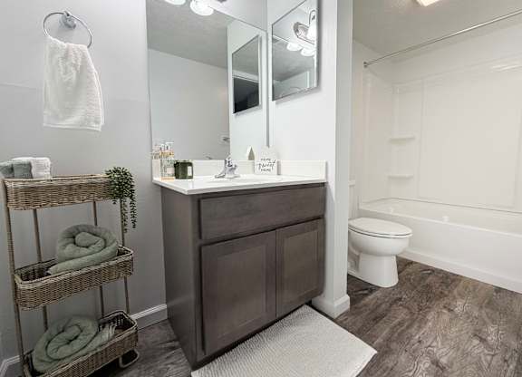 A bathroom with a white toilet and a white bathtub.