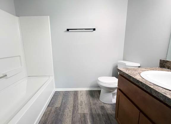 A white toilet sits in a bathroom next to a sink.