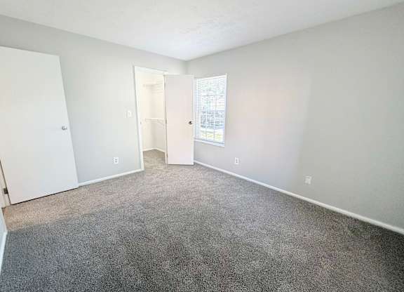 A room with a carpeted floor and white walls.