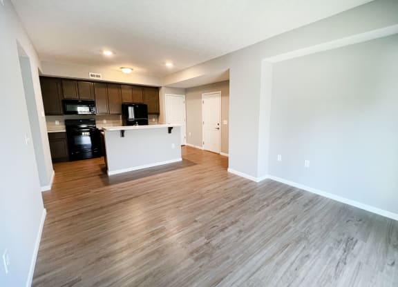 an empty living room and kitchen with wood flooring  at Brookfield Village Apartments, Grove City