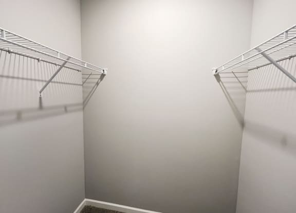 an empty closet with two shelves in a room with white walls  at Brookfield Village Apartments, Ohio, 43123