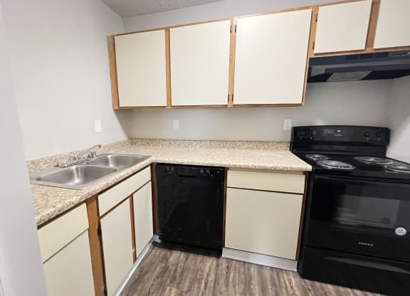Kitchen with white cabinets and black appliances at 450 on Keeneland Apartments, Richmond