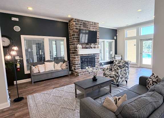 A living room with a grey couch, a fireplace, and a television.