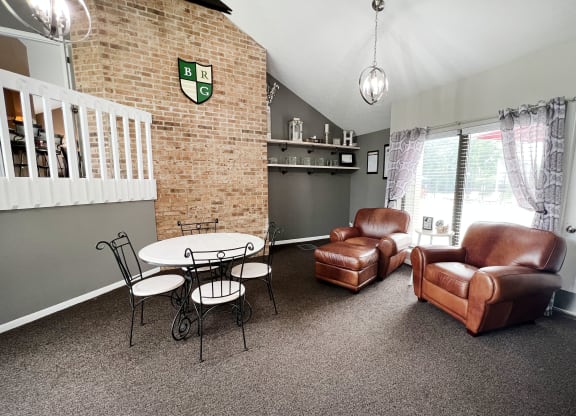 a living room with a couch and chair and a table and chairs  at Hunter's Creek Apartments, Cincinnati, OH
