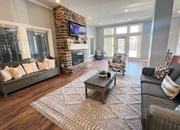 a living room with a brick fireplace and couches at The Residences at Liberty Crossing, Columbus, OH, 43235