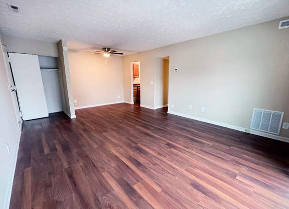 A room with wooden flooring and a ceiling fan.