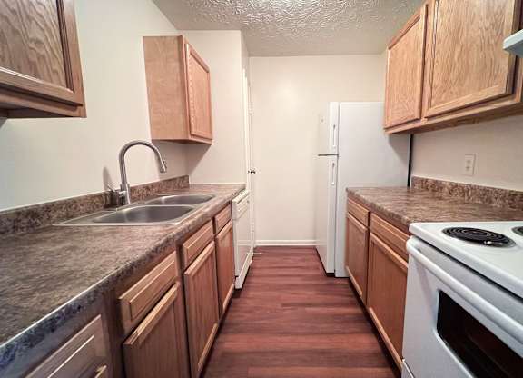 A kitchen with wooden cabinets and a white oven.