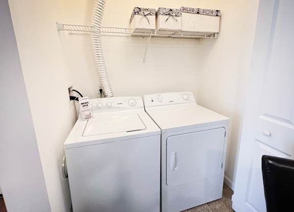 a white washer and dryer in a white laundry room