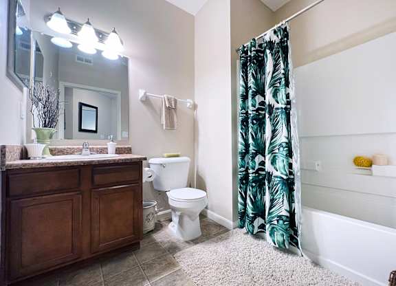 A bathroom with a toilet, sink, and shower.