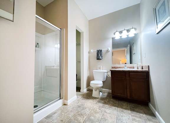 A bathroom with a toilet, sink, and mirror.
