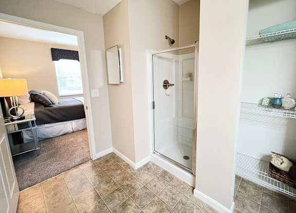 a bathroom with a shower and a bedroom with a bed at The Residences at Liberty Crossing, Columbus
