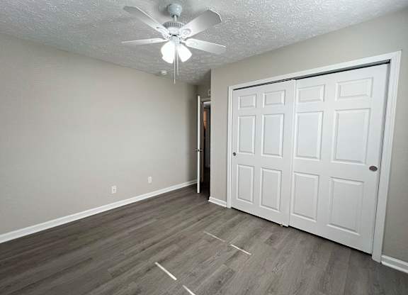A room with a white ceiling fan and a white door.