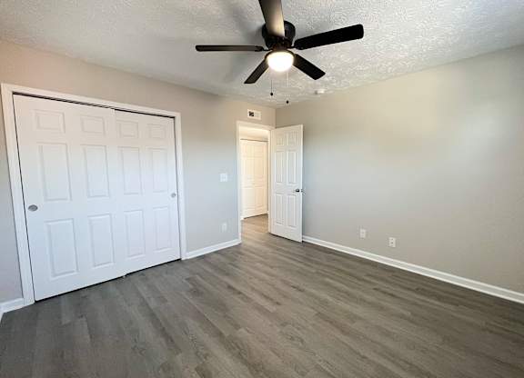 A room with a ceiling fan and two doors.