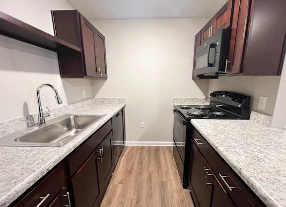 A kitchen with brown cabinets and a white counter top.