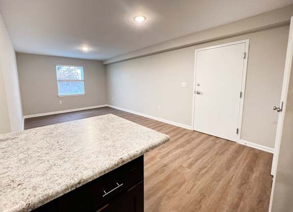A room with a marble countertop and wooden flooring.