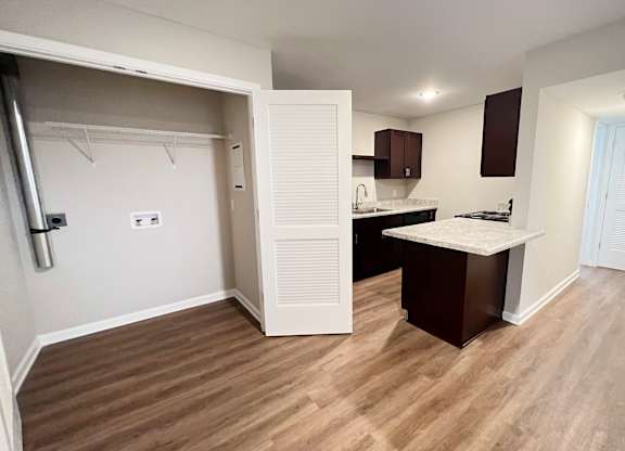 A kitchen area with a white countertop and brown cabinets.