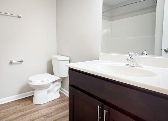 A white toilet sits next to a sink in a bathroom.