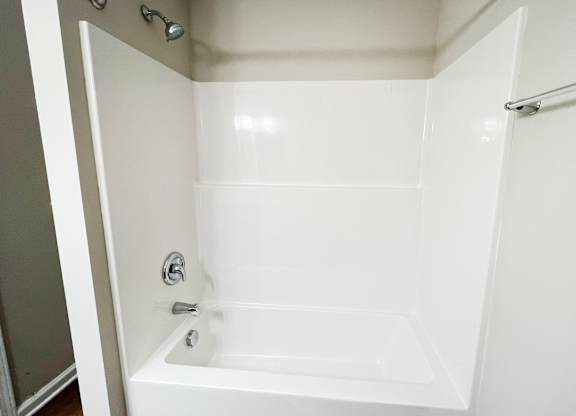 A white bathroom with a tub and shower.