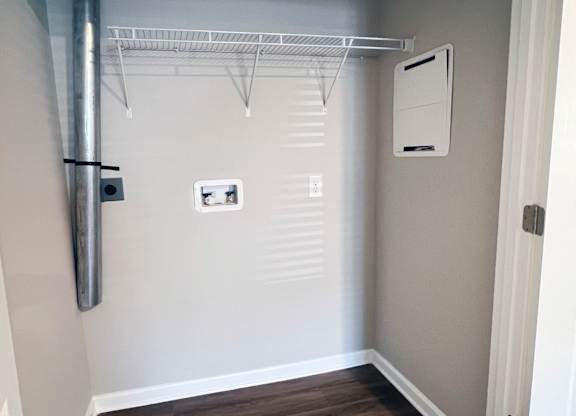 A white closet with a shelf and a white door.