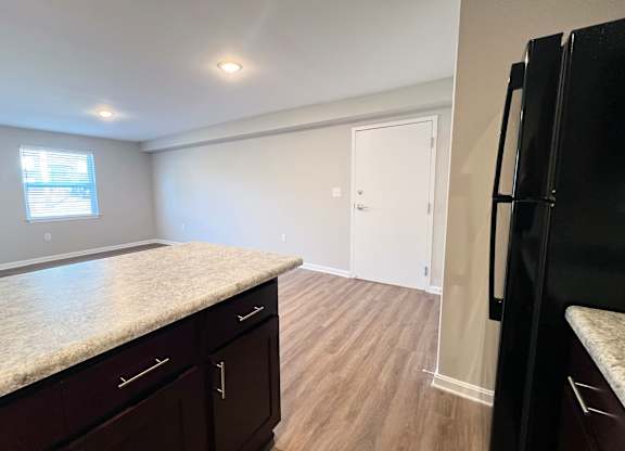 A kitchen with dark wood cabinets and a granite countertop.