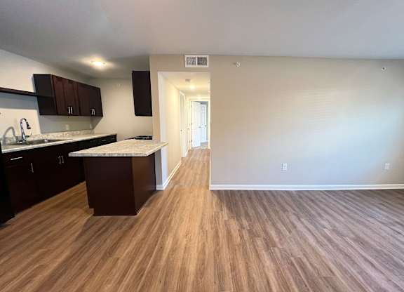 A kitchen with dark wood cabinets and a white countertop.