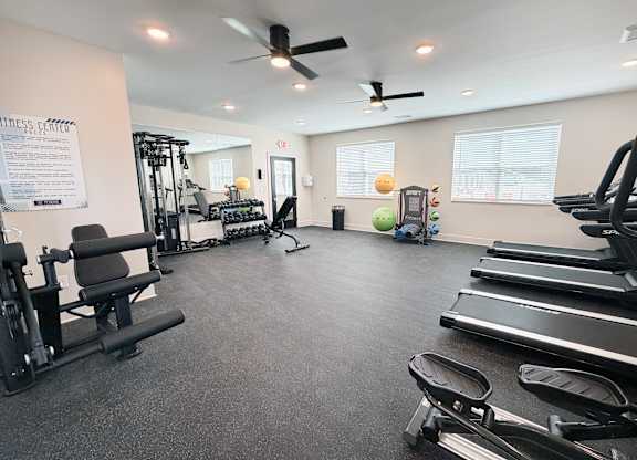 A gym with treadmills, weights, and exercise equipment.