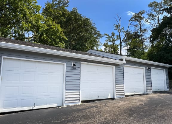a row of three garage doors on the side of a building at Deercross Apartments, Cincinnati, 45236