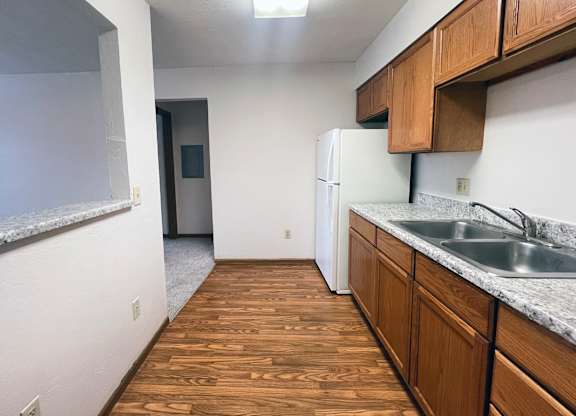 A kitchen with wooden floors and white appliances.