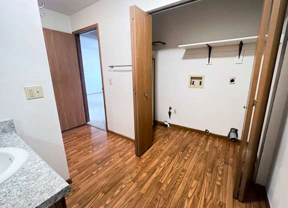 A bathroom with a wooden floor and a sink.
