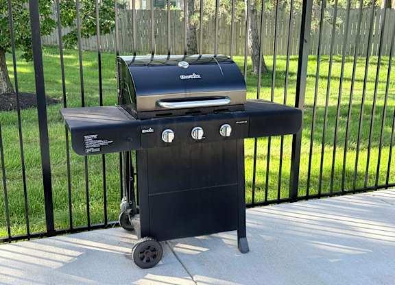A charcoal grill is on a patio.
