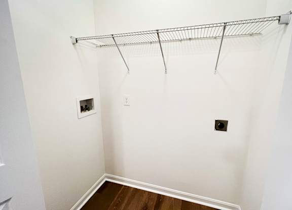 a room with a white wall and a closet with a rack on the wall at The Residences at Liberty Crossing, Columbus, 43235