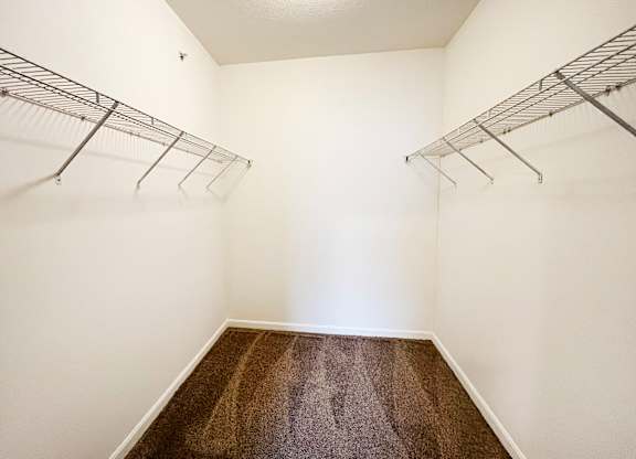 a room with two hanging racks on the wall and a carpeted floor