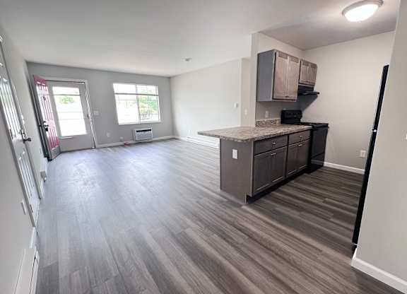 A kitchen with a counter and cabinets is visible in the image.