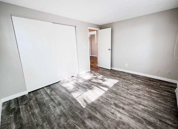 A room with a white door and a grey floor.
