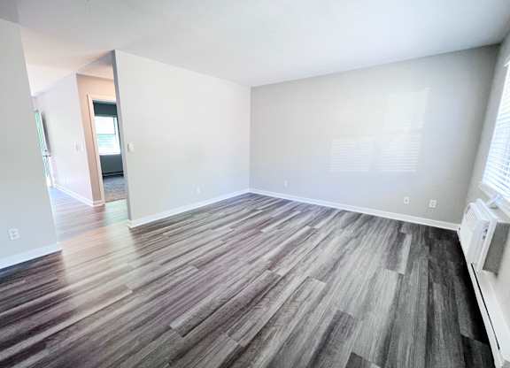 A room with a wooden floor and white walls.