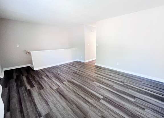 A room with wooden flooring and white walls.
