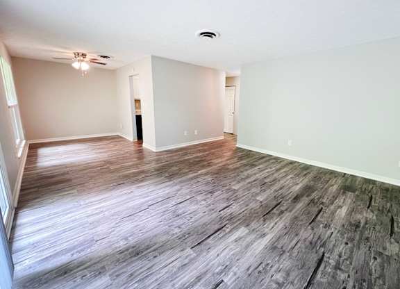 A room with wooden flooring and white walls.