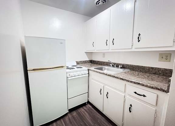 Efficiency: A kitchen with white appliances and cabinets.