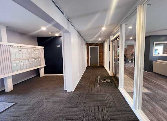 A hallway with a carpeted floor and white walls.